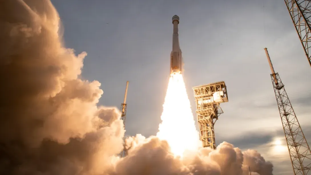 A rocket being launched, with a huge plume of smoke and fire shooting out of it.